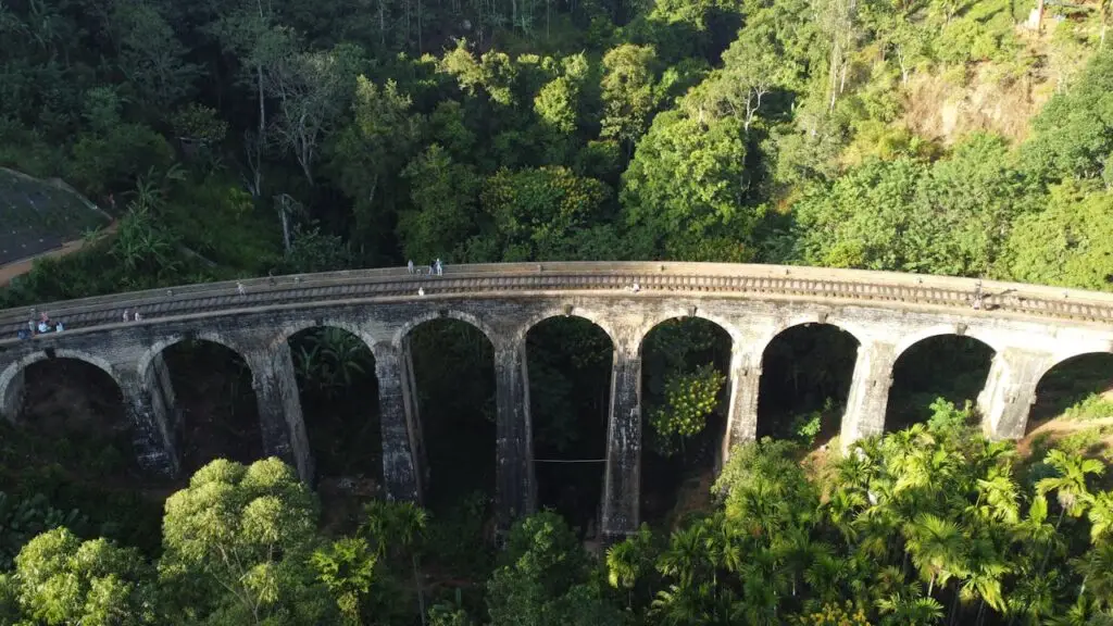 Stunning aerial view of Nine Arches Bridge amidst lush green forest in Sri Lanka.