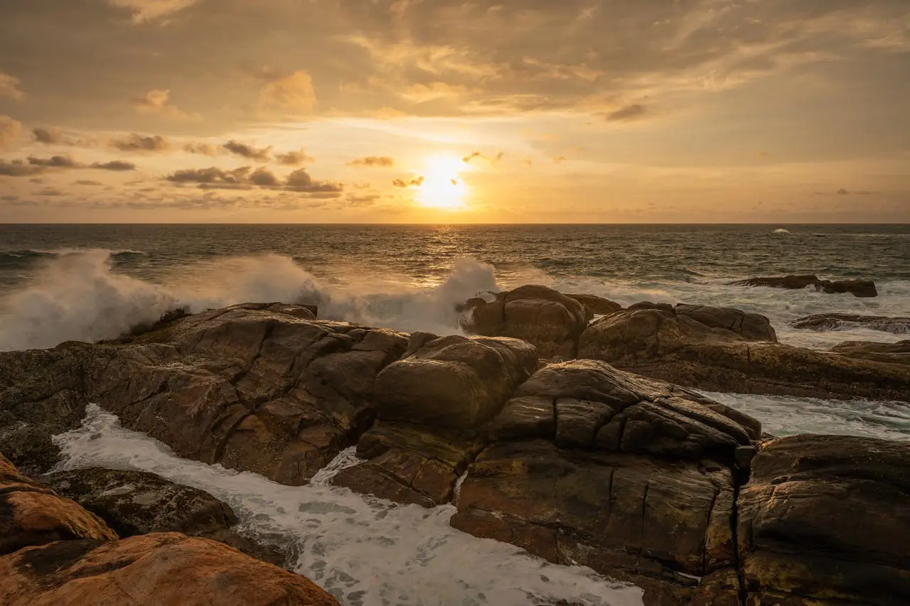 Captivating sunset over rocky coastline with waves crashing in Sri Lanka's serene natural beauty.